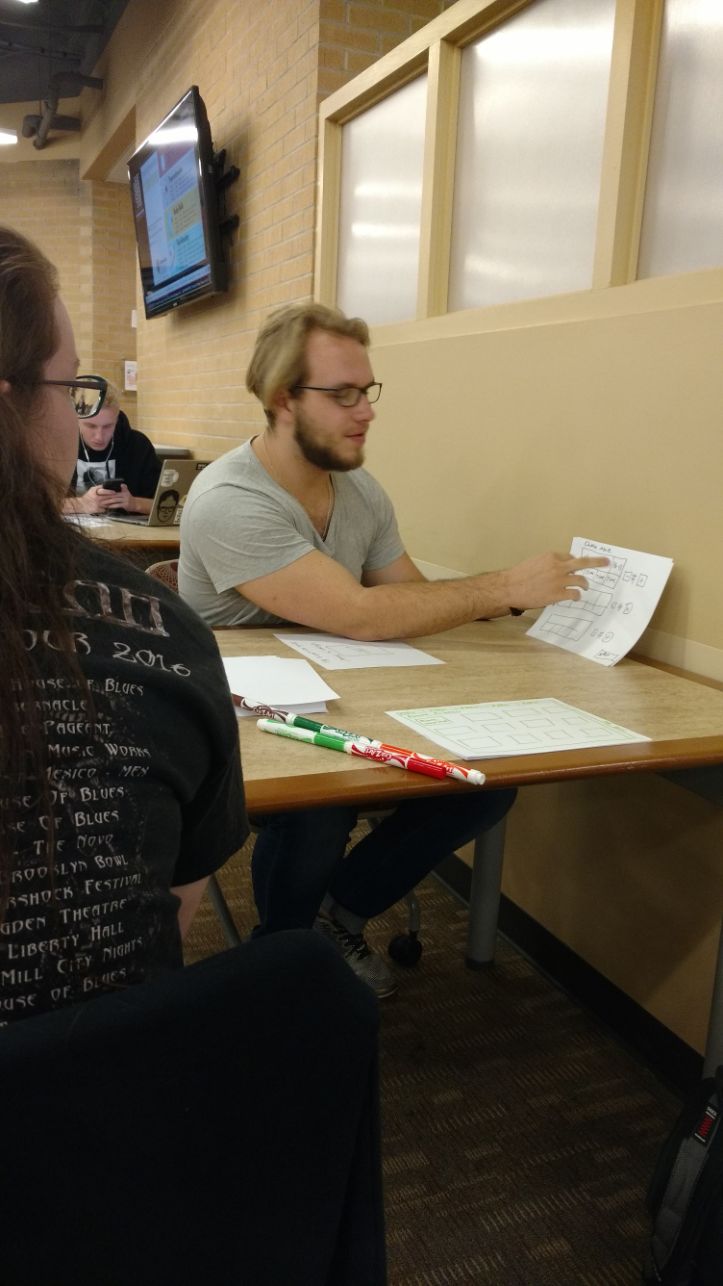 A picture of me discussing ideas with the team for our paper prototype