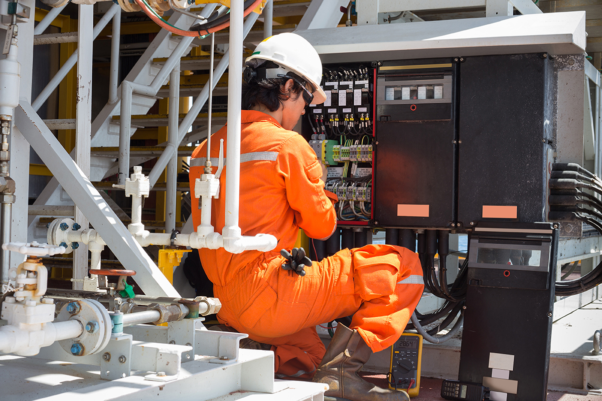 A man working on electrical components in a commercial building