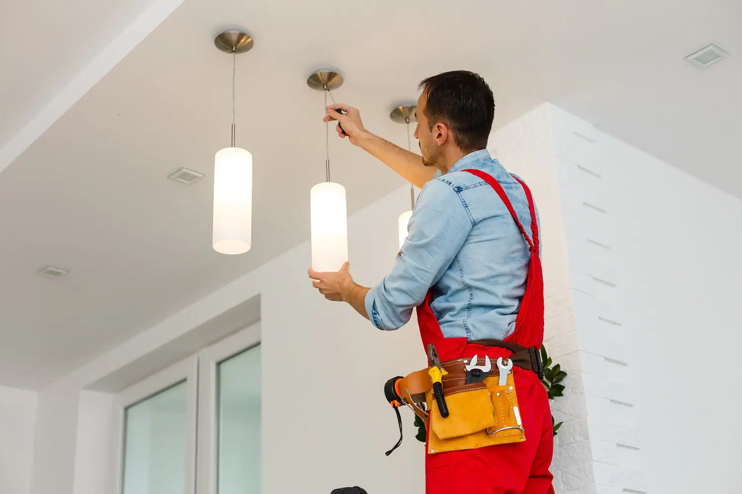 A man installing lighting inside a house